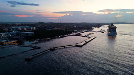 cruise ship docks at historic caribbean port town at sunset