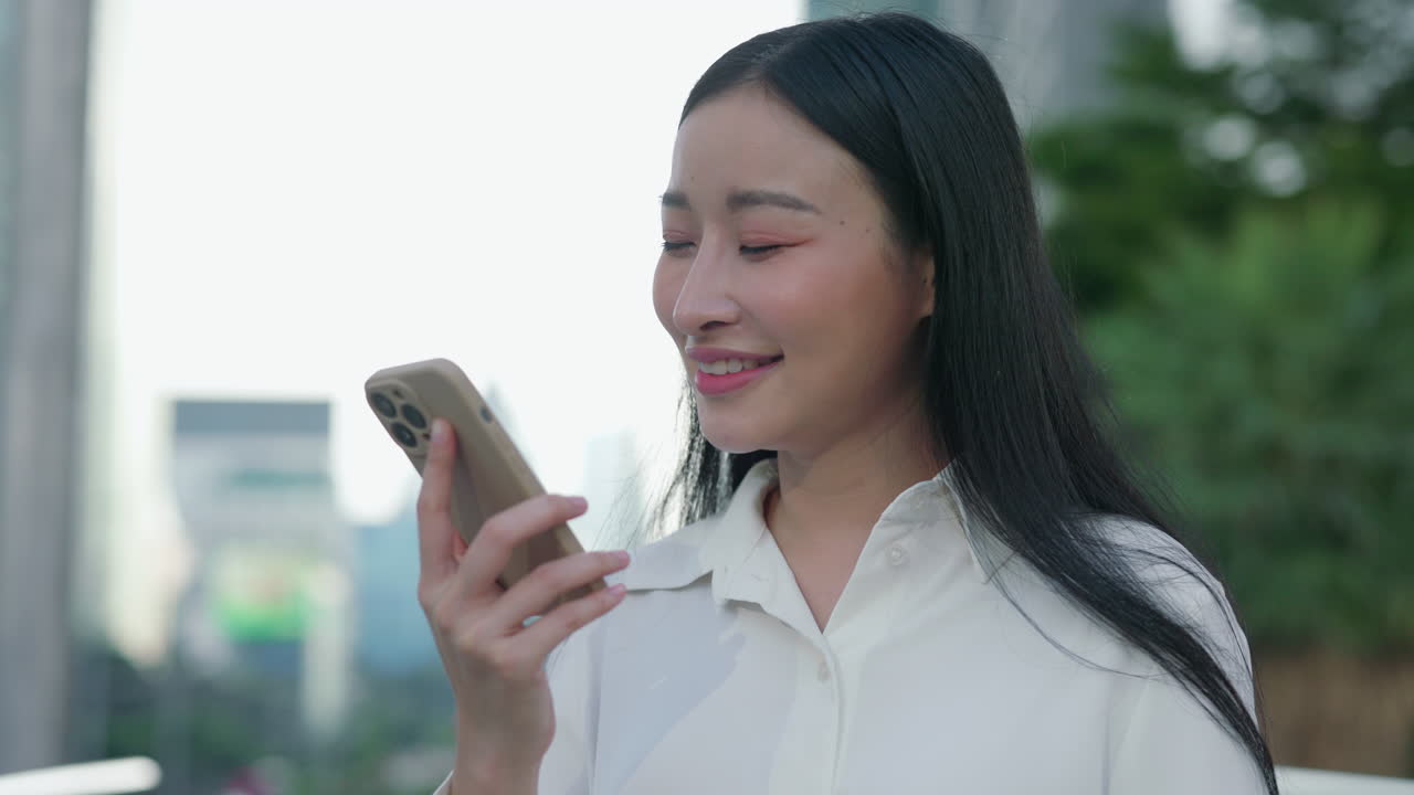 Young Asian Woman Using Smartphone Outdoors in Urban Setting
