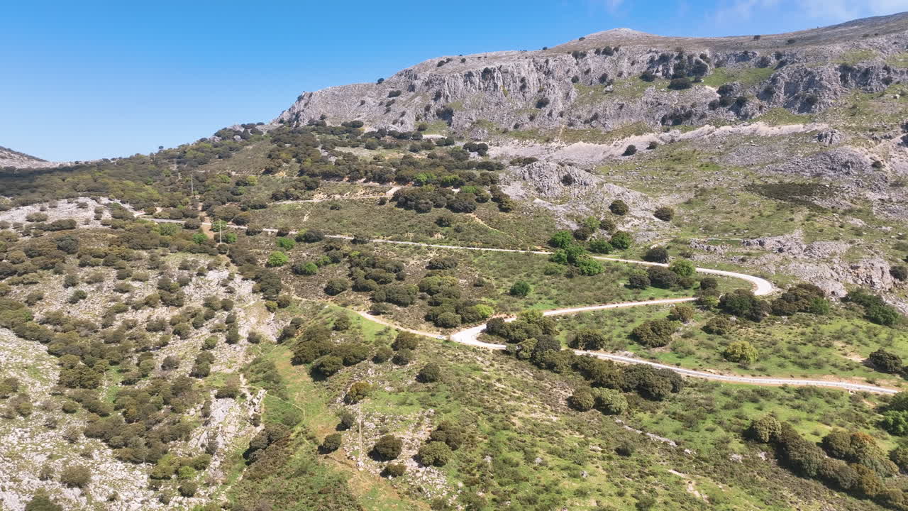 Vista aerea di un ripido pendio boschivo con una strada a zig zag spettacolare, Sierra de San Jorge