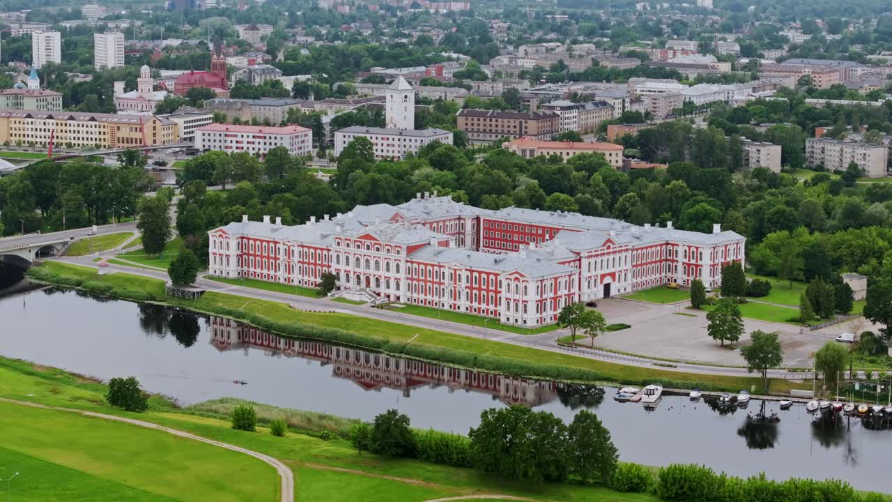 Smooth aerial of Jelgava Palace by Lielupe river, reflections, greenery Latvia