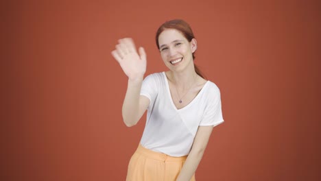 happy woman waving at camera.