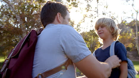 Father Fastening Son&#039;s Backpack As They Get Ready For Hike