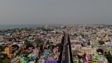 drone view of congested city with metro passing thorugh during daytime.