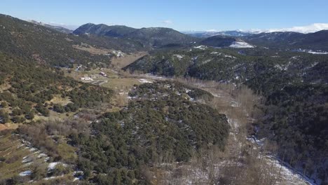 Aerial-panoramic-view-of-the-stream-of-a-river-with-snow-and-fallen-leafs-trees