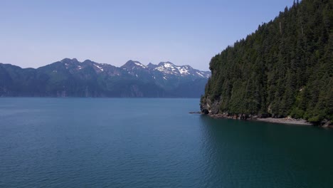 4K-Drohnenaufnahmen-Aus-Der-Luft-Entlang-Der-Küste-In-Der-Nähe-Von-Seward,-Alaska,-Die-Offenes-Wasser-Und-Schneebedeckte-Berge-Zeigen