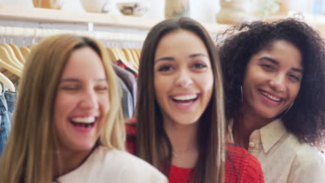 retrato de tres amigas divirtiéndose comprando ropa en una tienda juntos