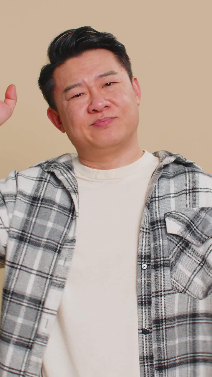 Confused asian man pointing at camera showing stupid asking for insane crazy bad plan bullying