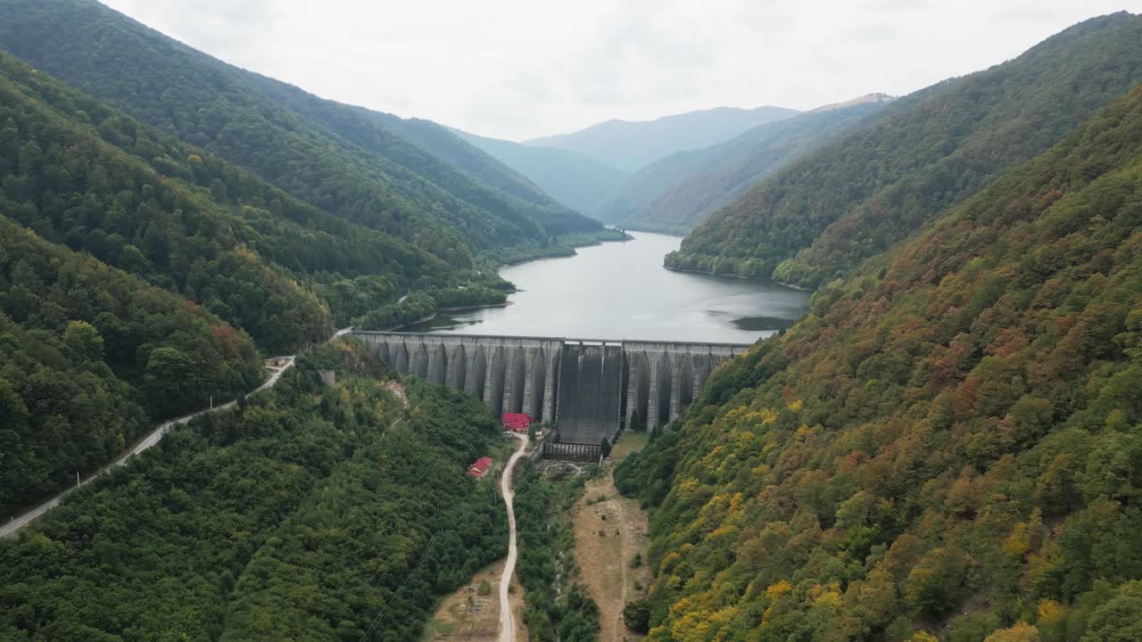 very big dam, sea or reservoir in a beautiful valley between a big forest, carpathians, romania, europe, drone, summer