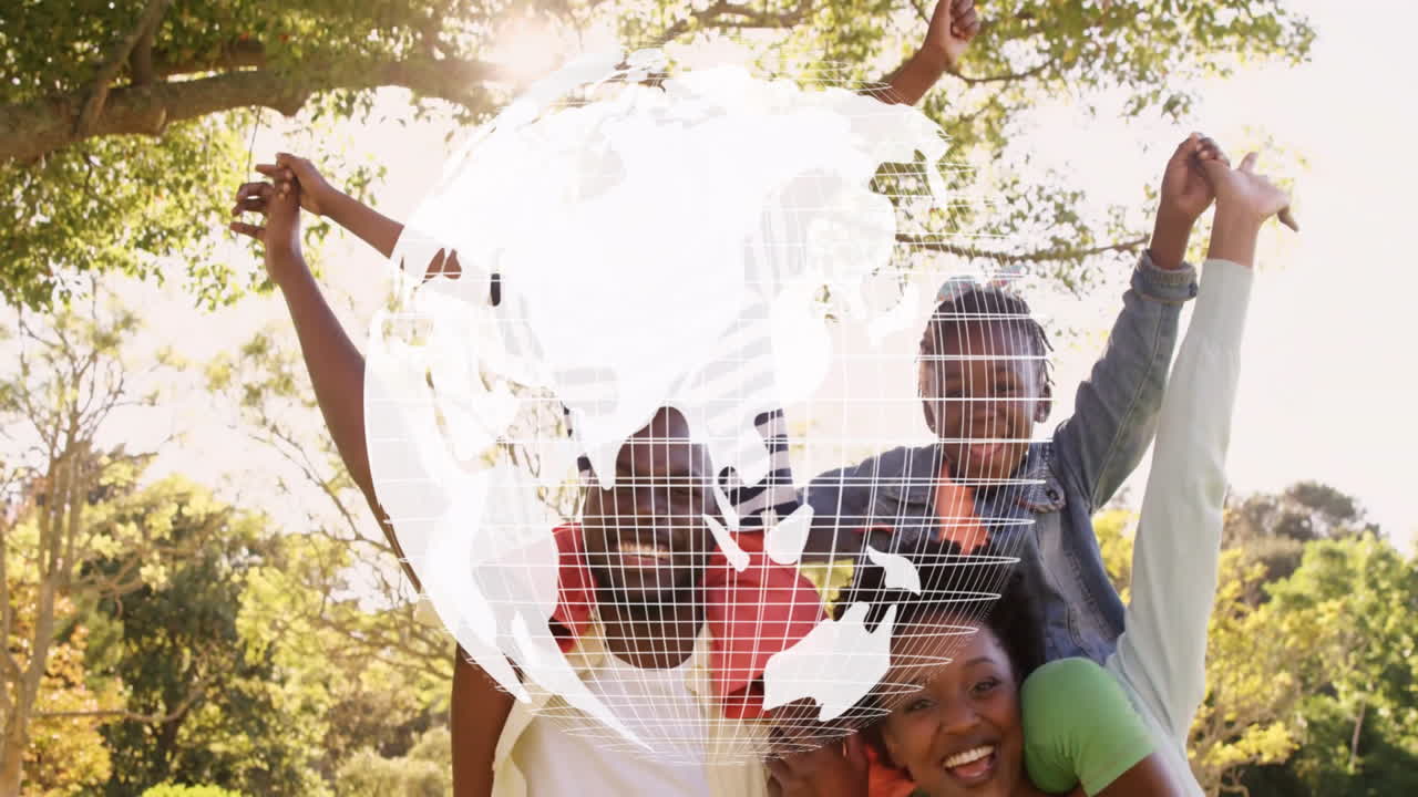 Family celebrating under sunlit park, featuring digital globe grid overlay for technology