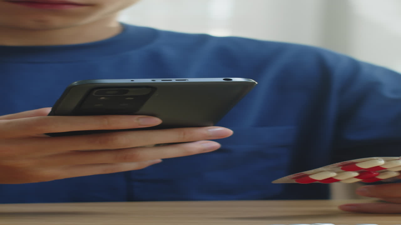 Man Reading Instruction on Smartphone before Taking Pills