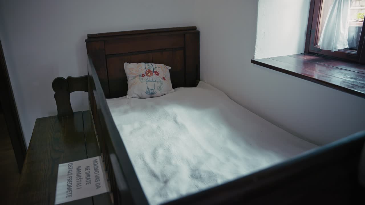 Traditional wooden bed with embroidered pillow in Kumrovec museum, Croatia
