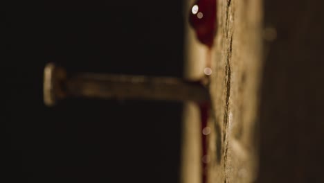 religious concept shot with close up of droplet of blood on old rusty nail in wooden cross 1