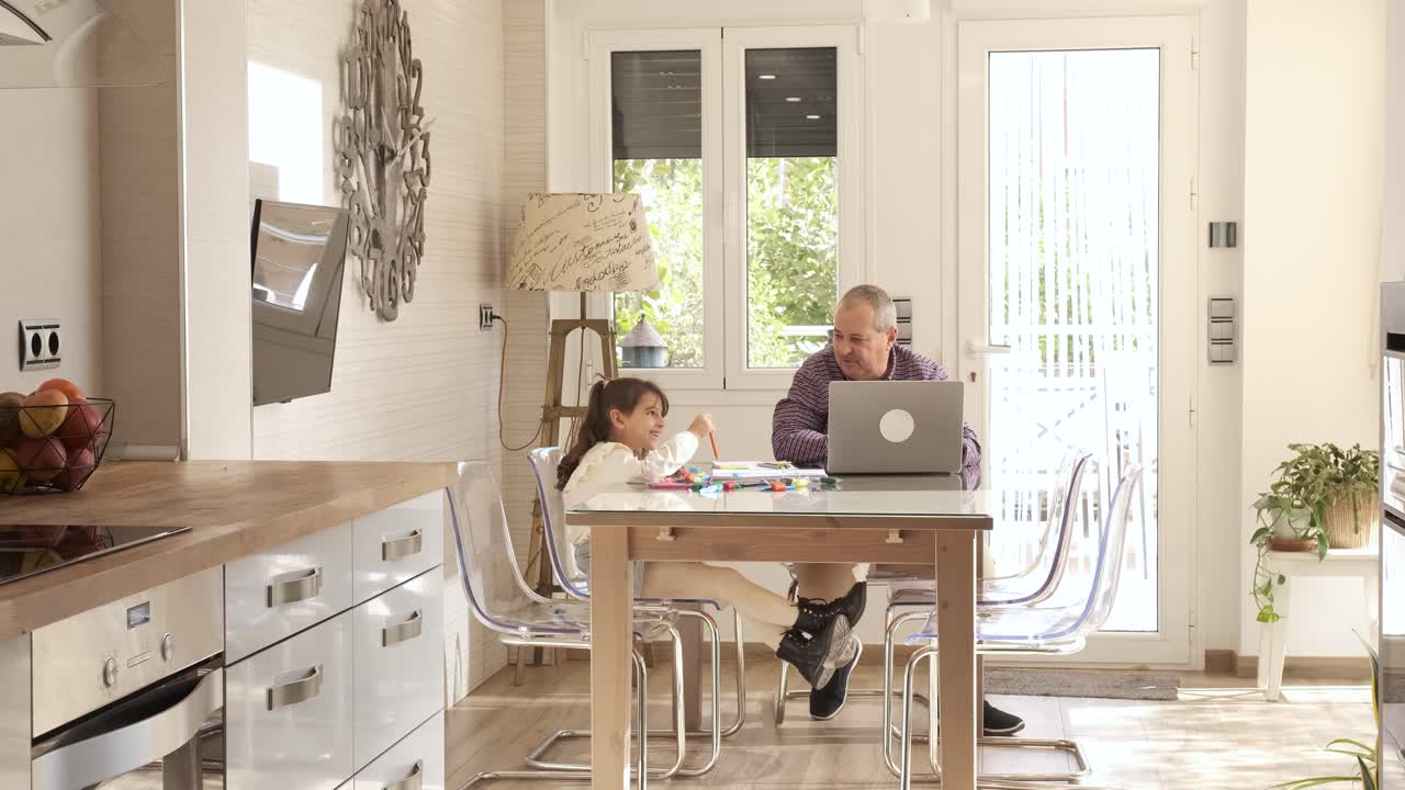 Girl playing while her grandfather working next to them