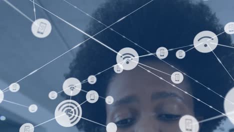 Animation-of-network-of-digital-icons-against-close-up-of-african-american-woman-at-office
