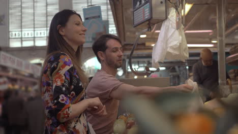 Una-Pareja-Comprando-Frutas-En-Un-Mercado-Local