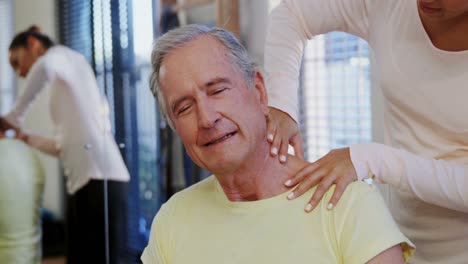 physiotherapist giving neck massage to senior patient 4k