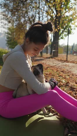 woman hugging pug in autumn park