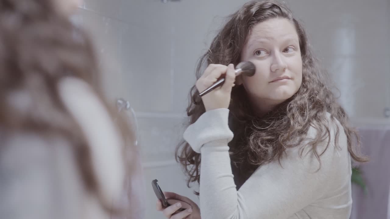 Woman's Beauty Routine in the Bathroom Mirror