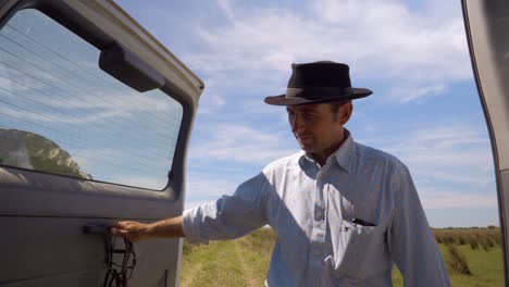 Cowboy-farmer-opening-the-trunk-of-the-truck-and-gets-the-rope-out