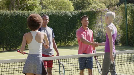 Happy-diverse-group-of-friends-shaking-hands-at-tennis-court