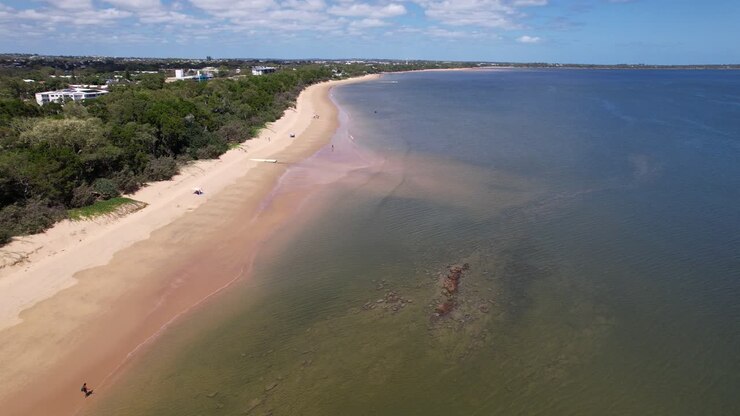 Volando sopra le acque calme di Hervey Bay a Torquay Beach.