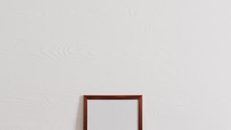 marco de madera con espacio de copia sobre fondo blanco y pared blanca