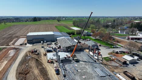 aerial shot of a construction site with crane and steel beams in rural pennsylvania showcasing industrial activity vibrant colors rich detail cinematic quality