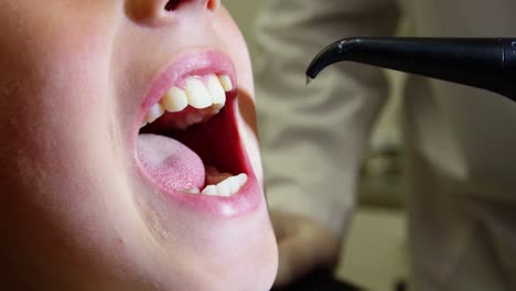 dentista examinando a un paciente joven con herramientas dentales