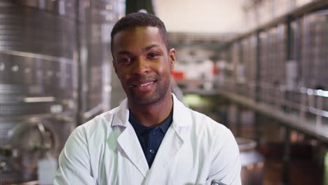 Young-black-man-working-at-a-wine-factory-walking-into-focus