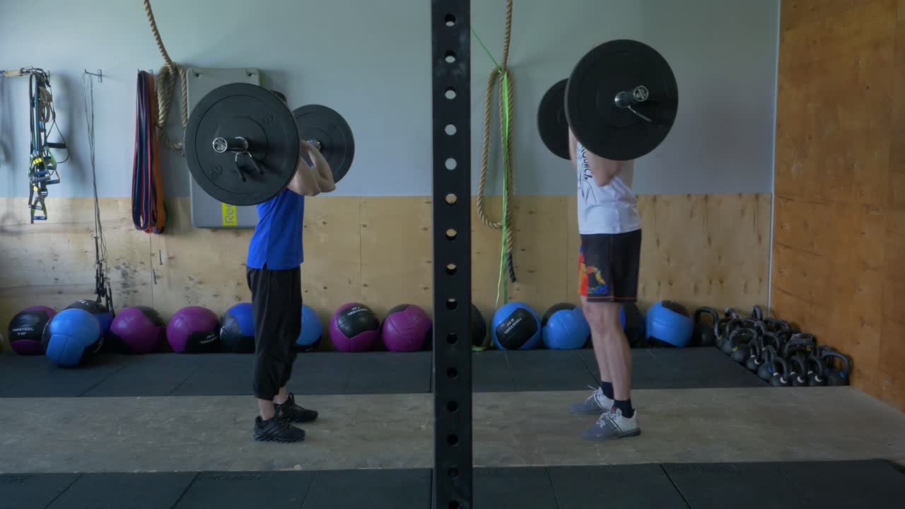 체육관 에서 웨이트 리프팅 을 하는 두 사람
