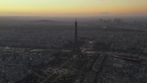 Slide-and-pan-footage-of-tall-dominant-of-city,-old-and-famous-Eiffel-Tower.-Panoramic-view-of-large-town-at-dusk.-Paris,-France