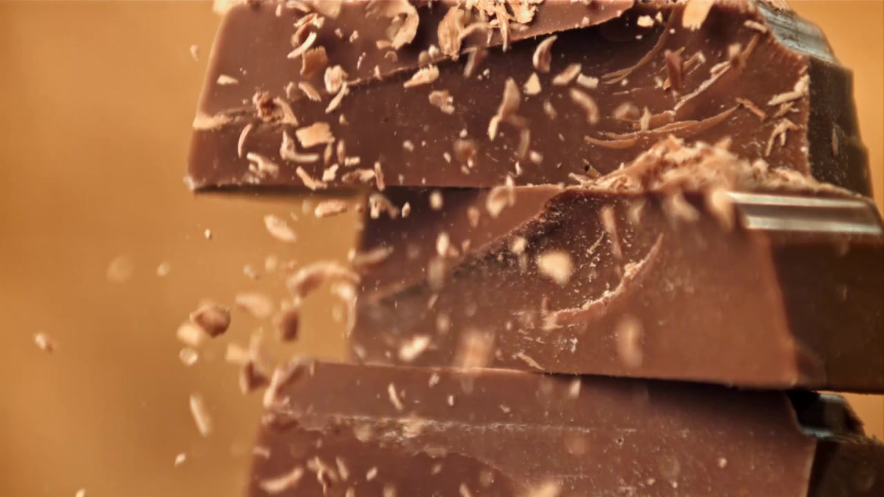 Scaglie di cioccolato che cadono su tavolette di cioccolato impilate