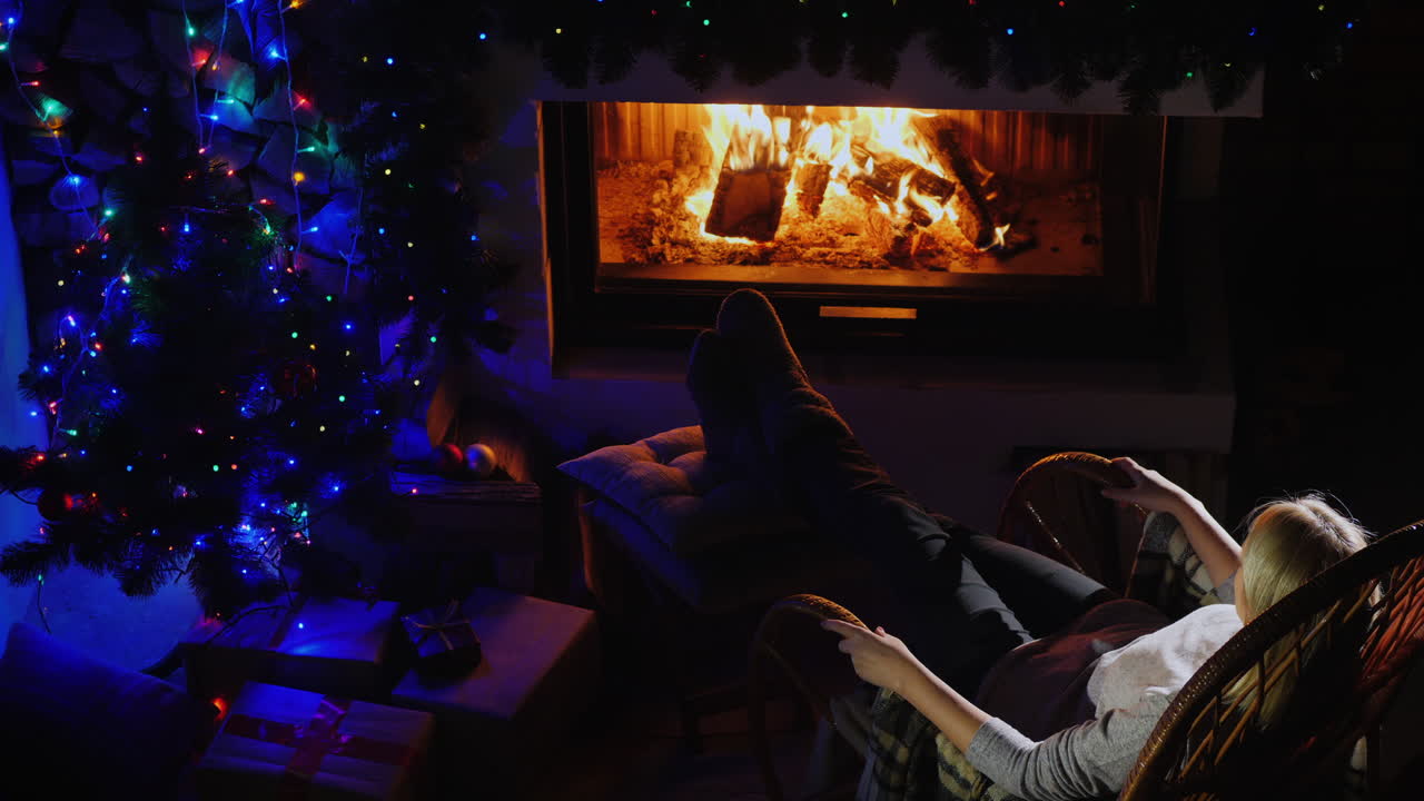 mujer descansando junto a la chimenea en la vista superior de la víspera de navidad