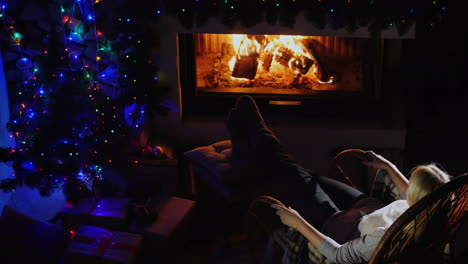 mujer descansando junto a la chimenea en la vista superior de la víspera de navidad