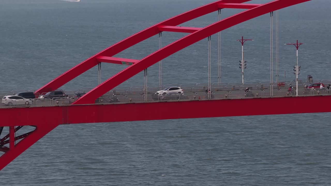 Close up aerial drone video of a red bridge in Taiwan, showcasing modern infrastructure, transportation connectivity, and mobility across urban and natural landscapes