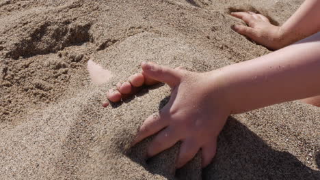 children burying feet in the sand on the beach