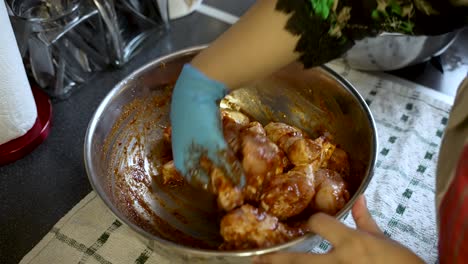 asian cook hand marinates halal chicken in spicy aromatic sauce in kitchen