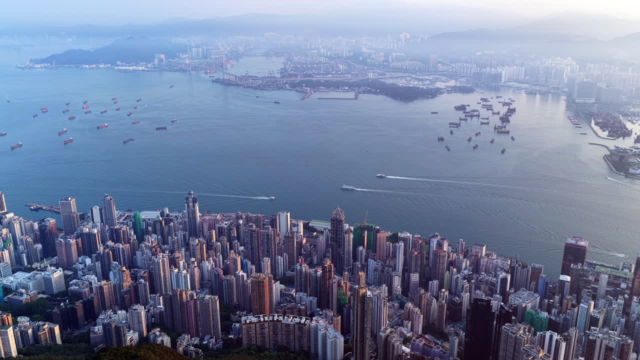 Cinematic aerial view of the Hong Kong skyline in morning light with cloud cover, showcasing the metropolitan city as a symbol of global finance, modern architecture, travel, and business