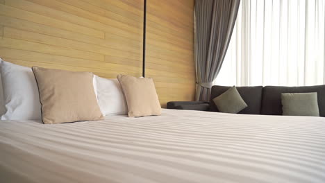 panning shot of a double bed inside a furnished hotel bedroom