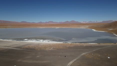 drone pans over wide kollpa lagoon revealing shallow waters and high-altitude desert