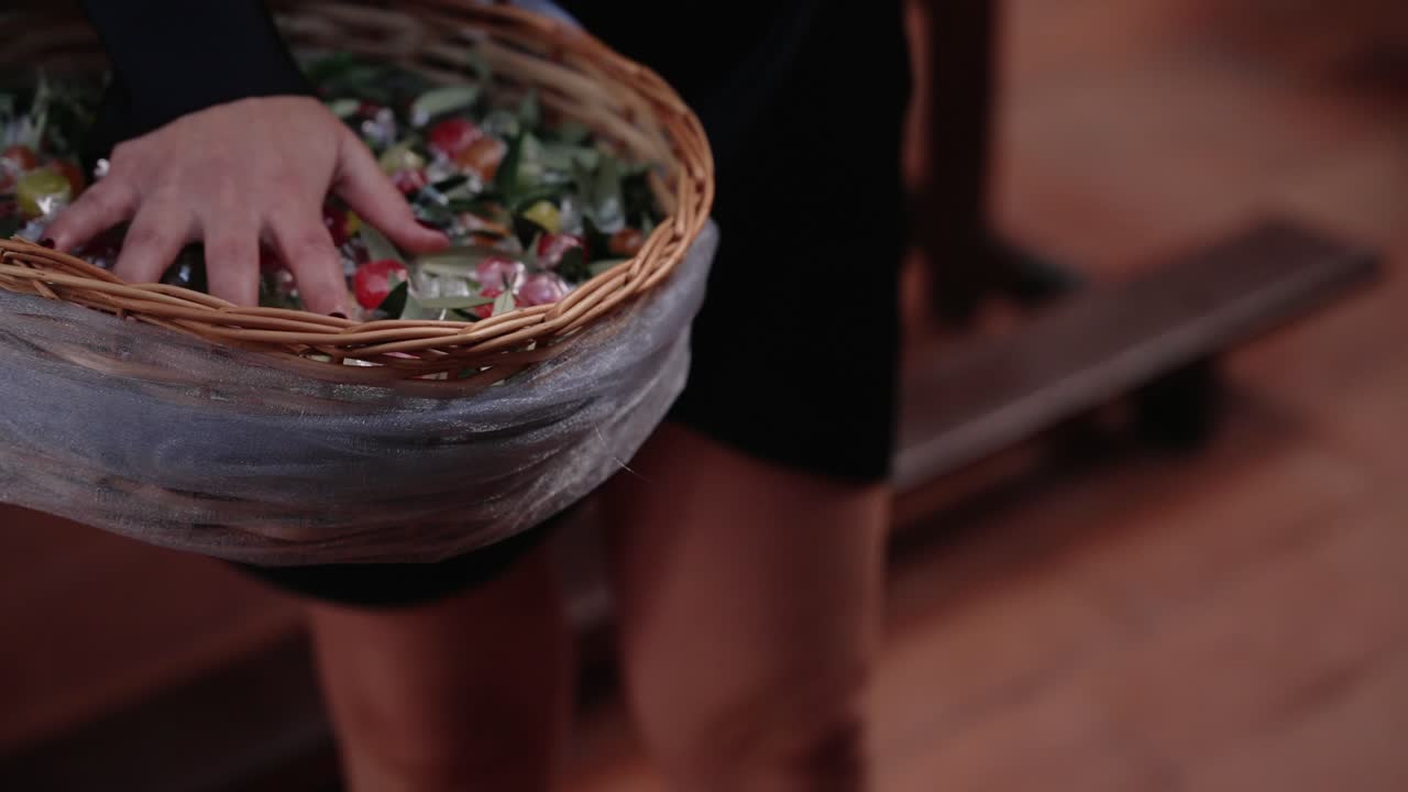 Close up decorative wedding basket filled with colorful wrapped candies