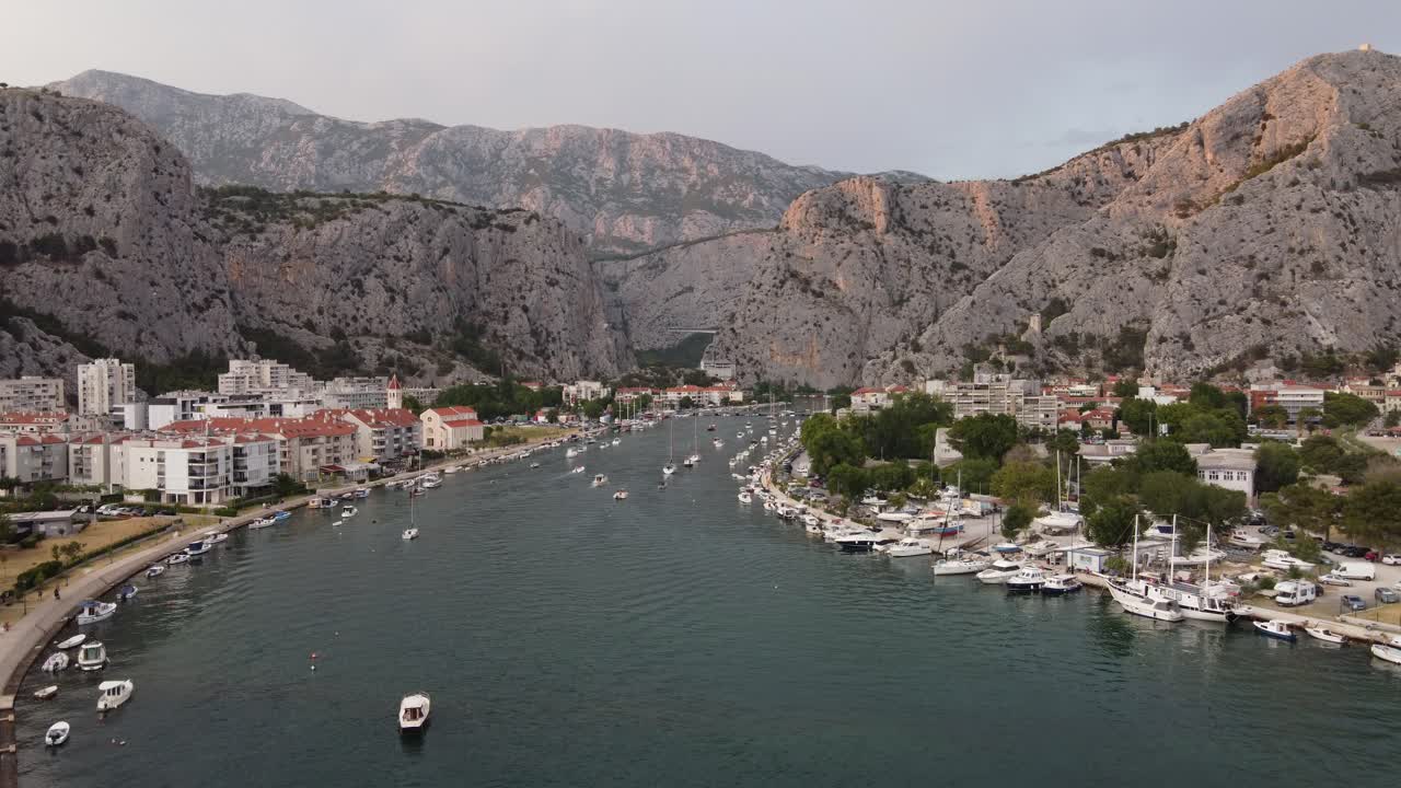 Aerial view of Boats and Yachts berthed at harbor of Cetina river mouth pier in Omis Town, Croatia