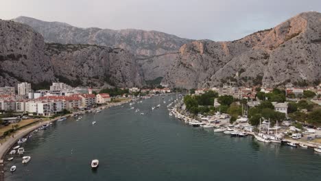 Vista-Aérea-De-Barcos-Y-Yates-Atracados-En-El-Puerto-Del-Muelle-De-La-Desembocadura-Del-Río-Cetina-En-La-Ciudad-De-Omis,-Croacia