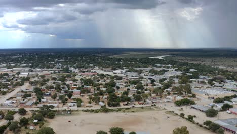 video aéreo de una ciudad rural africana con nubes de lluvia en el fondo