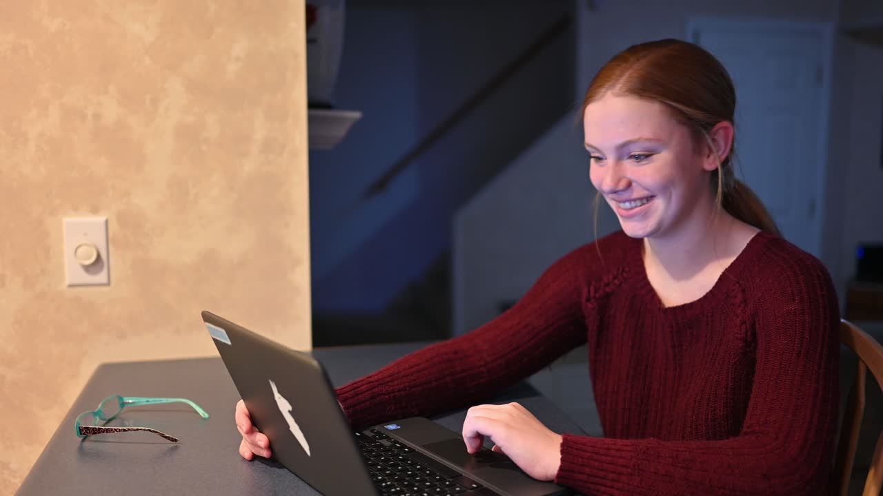 Den unge Madelyne søger på internettet og vender sig for at smile stort til kameraet.