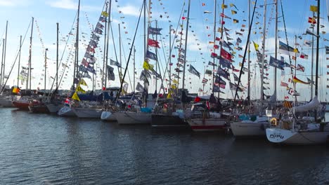 sailboats adorned with colorful flags docked in a marina