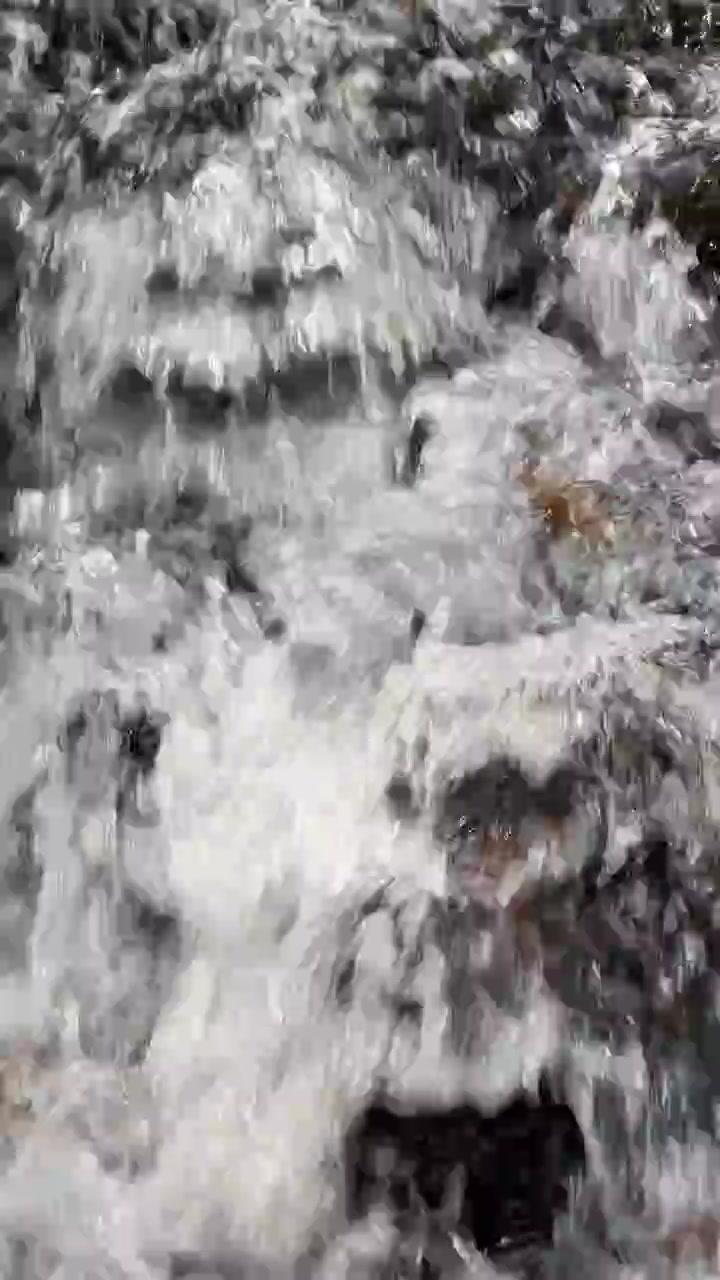 Primo piano di acqua limpida che scorre sulle rocce in un ruscello