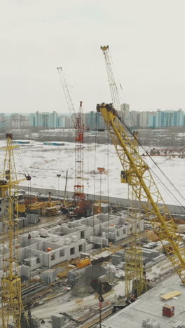 calm construction site of dwelling complex with tower cranes on nice winter weekend bird eye view