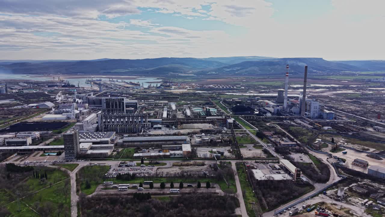 Zona industrial con fábricas y chimeneas cerca de una masa de agua