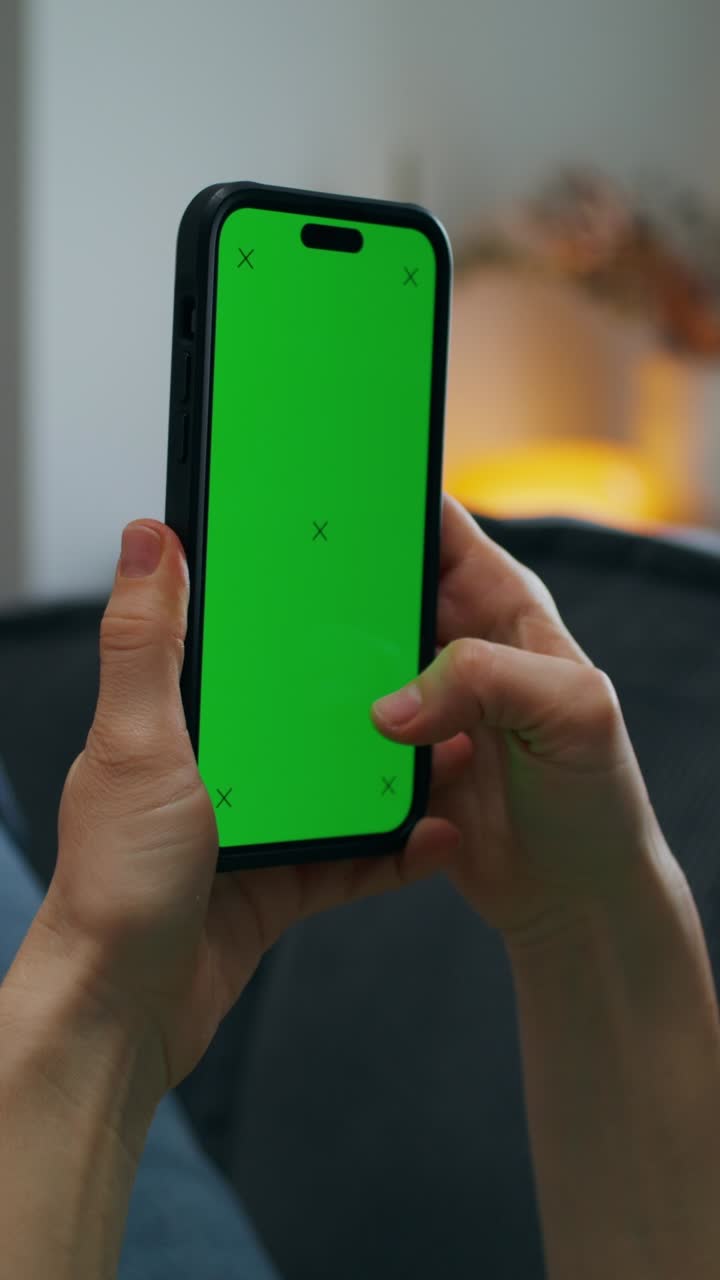 persona que sostiene un teléfono inteligente con una pantalla verde
